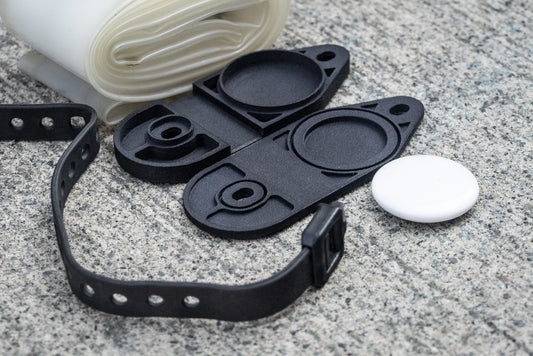 Image: The Standby Tube Strap Bracket, a clever bike accessory that conceals an Apple AirTag within a discreet bracket used to carry a spare tube on your bike. This lightweight and durable bracket is designed to blend in seamlessly and does not resemble a typical AirTag holder. It is specifically designed for use with Aerothan and Tubolito tubes and comes complete with a Voile Nano strap for easy installation. Made in Canada. angle open.