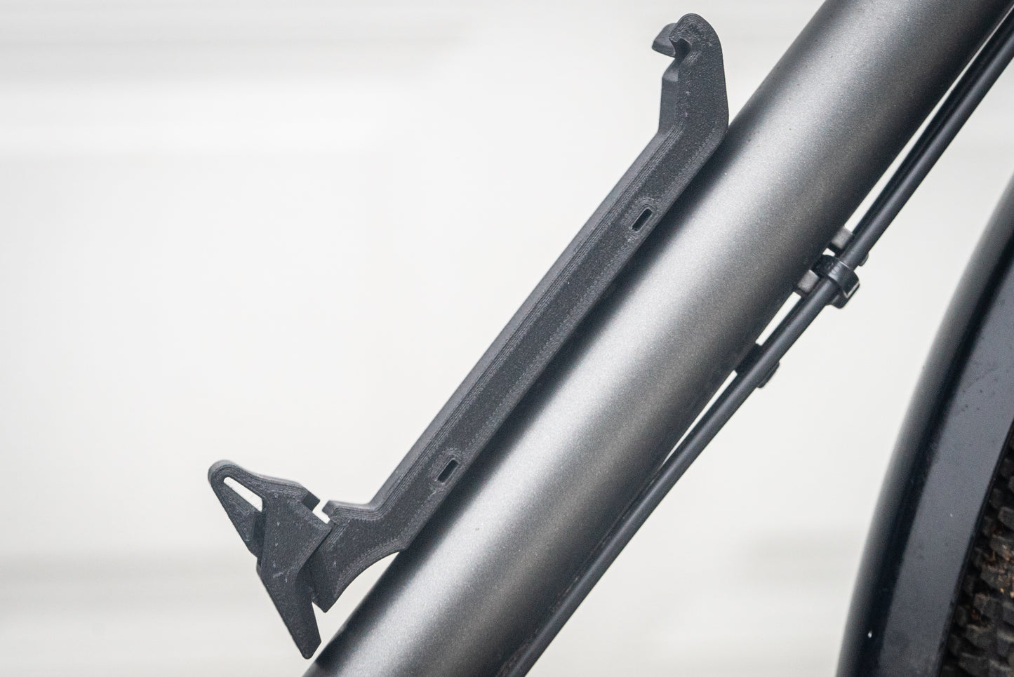 Image: The Canclaw, a lightweight and low-profile bike drink holder designed for standard 12oz (355ml) cans and 16oz (473ml) tall cans. It securely grips your beverage and can be attached using standard bottle cage bolt spacing or zipties. This product is 3D printed to order from ultra-strong carbon fiber nylon material and proudly made in Canada. Side product only.