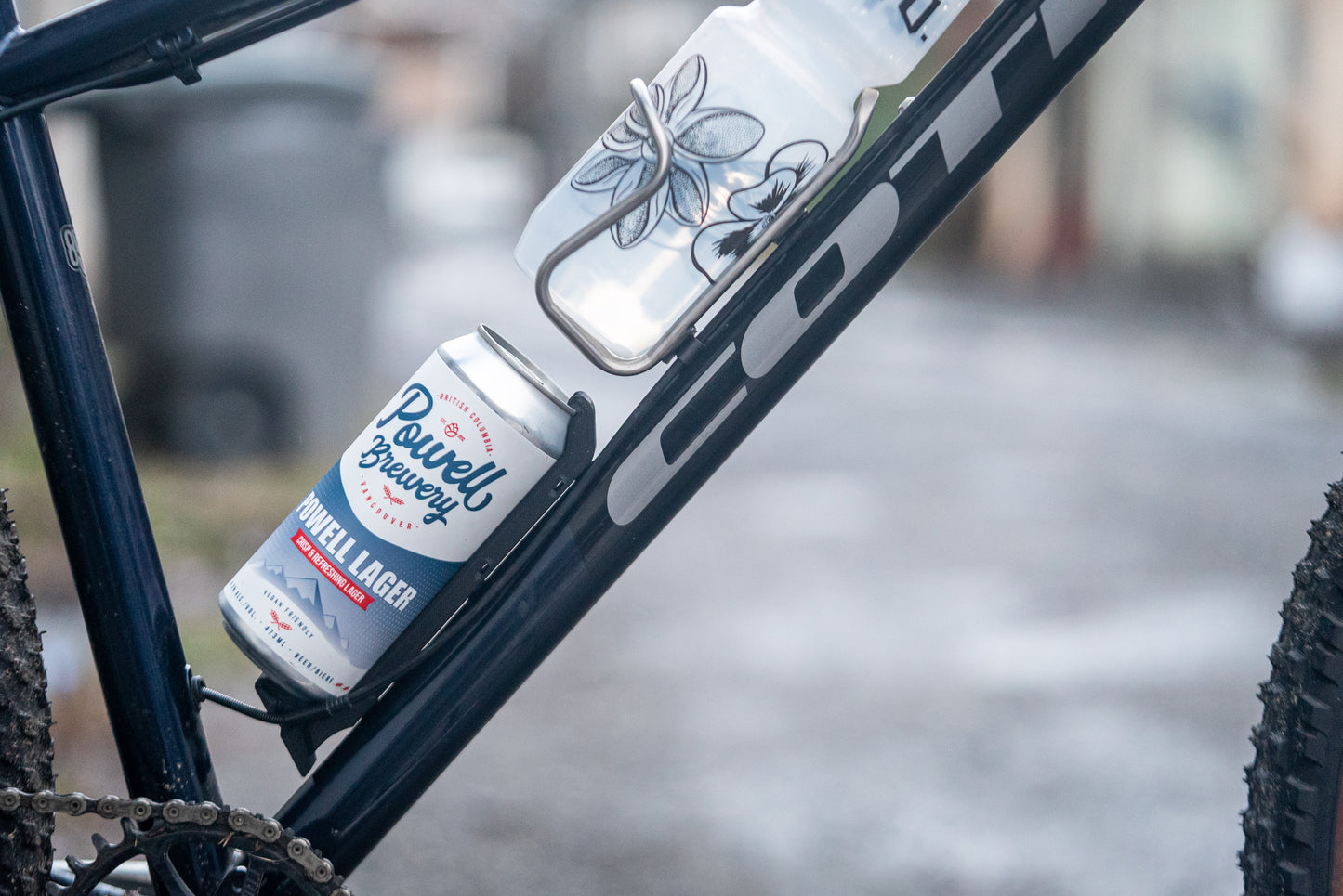 Image: The Canclaw, a lightweight and low-profile bike drink holder designed for standard 12oz (355ml) cans and 16oz (473ml) tall cans. It securely grips your beverage and can be attached using standard bottle cage bolt spacing or zipties. This product is 3D printed to order from ultra-strong carbon fiber nylon material and proudly made in Canada. Side.