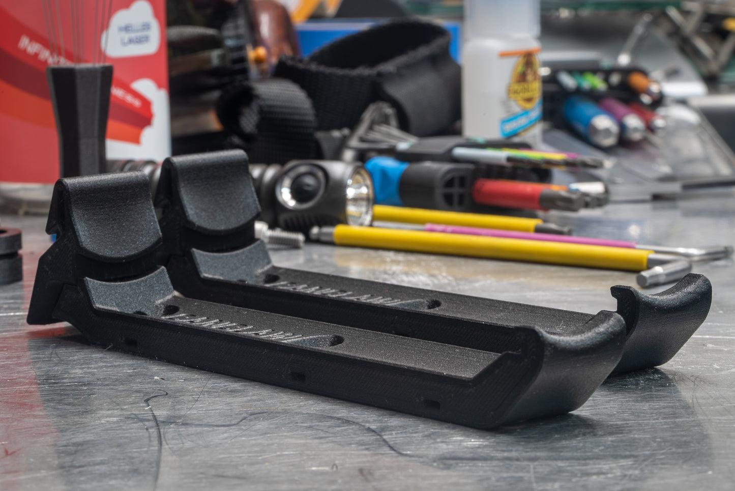 Image: The Canclaw, a lightweight and low-profile bike drink holder designed for standard 12oz (355ml) cans and 16oz (473ml) tall cans. It securely grips your beverage and can be attached using standard bottle cage bolt spacing or zipties. This product is 3D printed to order from ultra-strong carbon fiber nylon material and proudly made in Canada. Indoor.