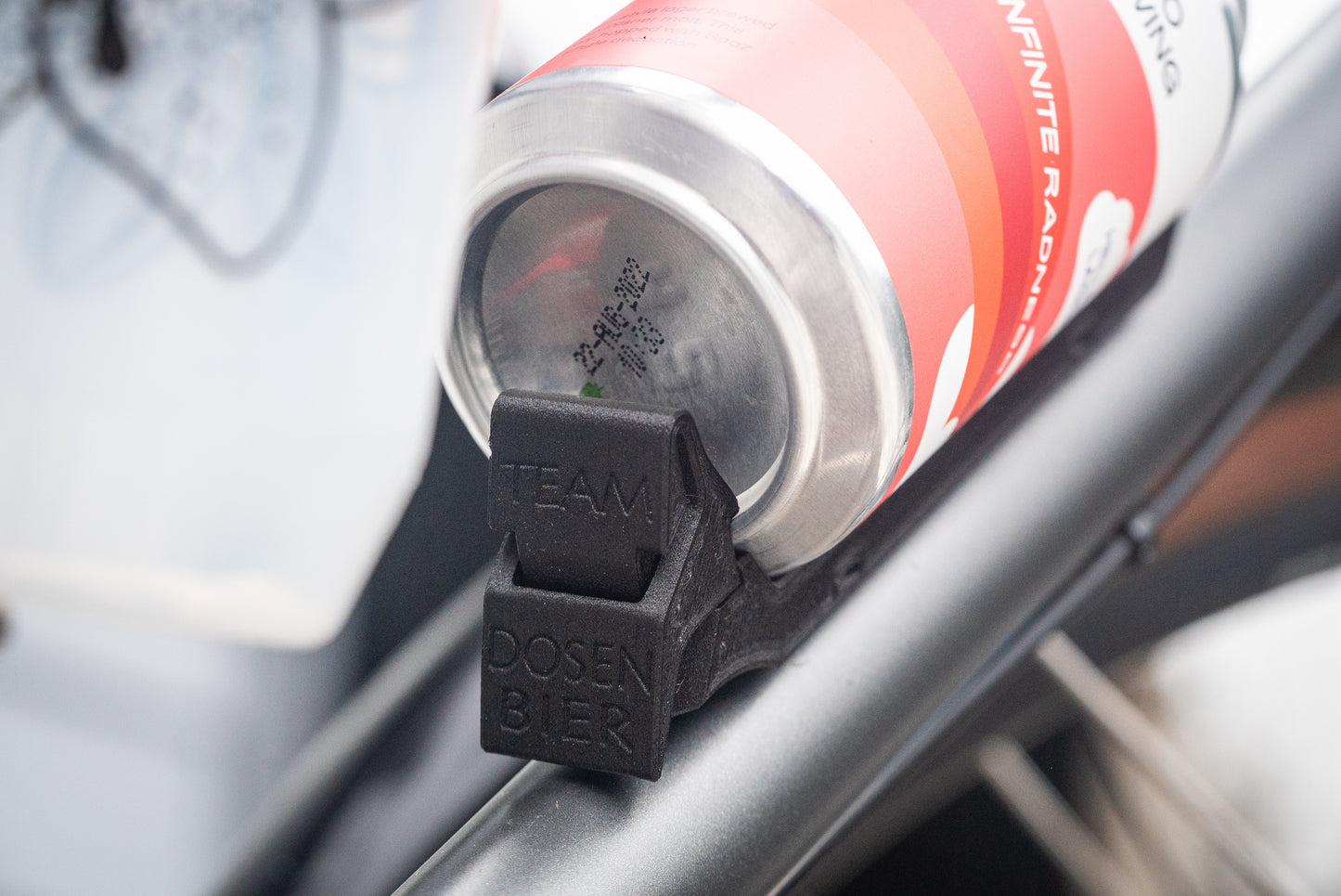 Image: The Canclaw, a lightweight and low-profile bike drink holder designed for standard 12oz (355ml) cans and 16oz (473ml) tall cans. It securely grips your beverage and can be attached using standard bottle cage bolt spacing or zipties. This product is 3D printed to order from ultra-strong carbon fiber nylon material and proudly made in Canada. Back closeup.
